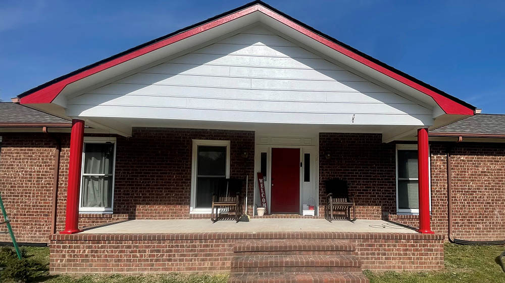 Finished brick ranch exterior with bright white gable and Red Bay accents